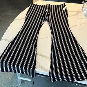 7 pair of pull on stretchy pants with wide leg bottom. Mixed prints. One black